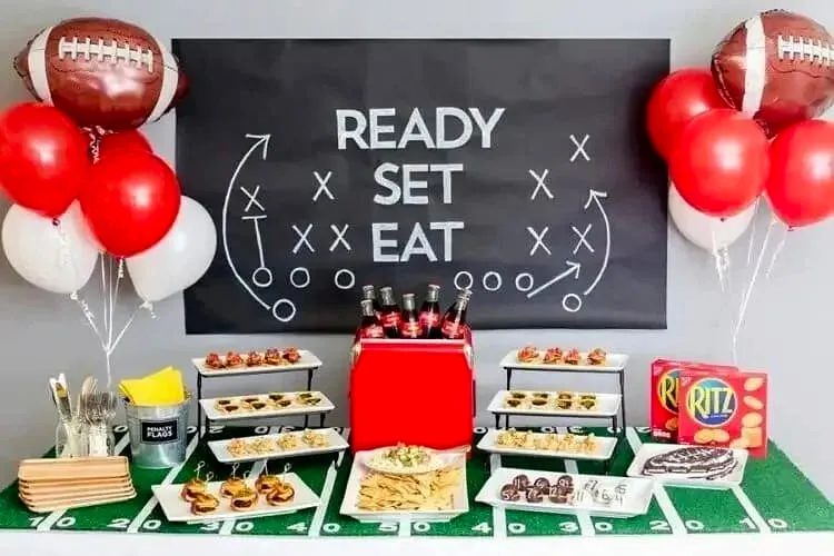 Football-themed party display with chalk board, balloons, and appetizers