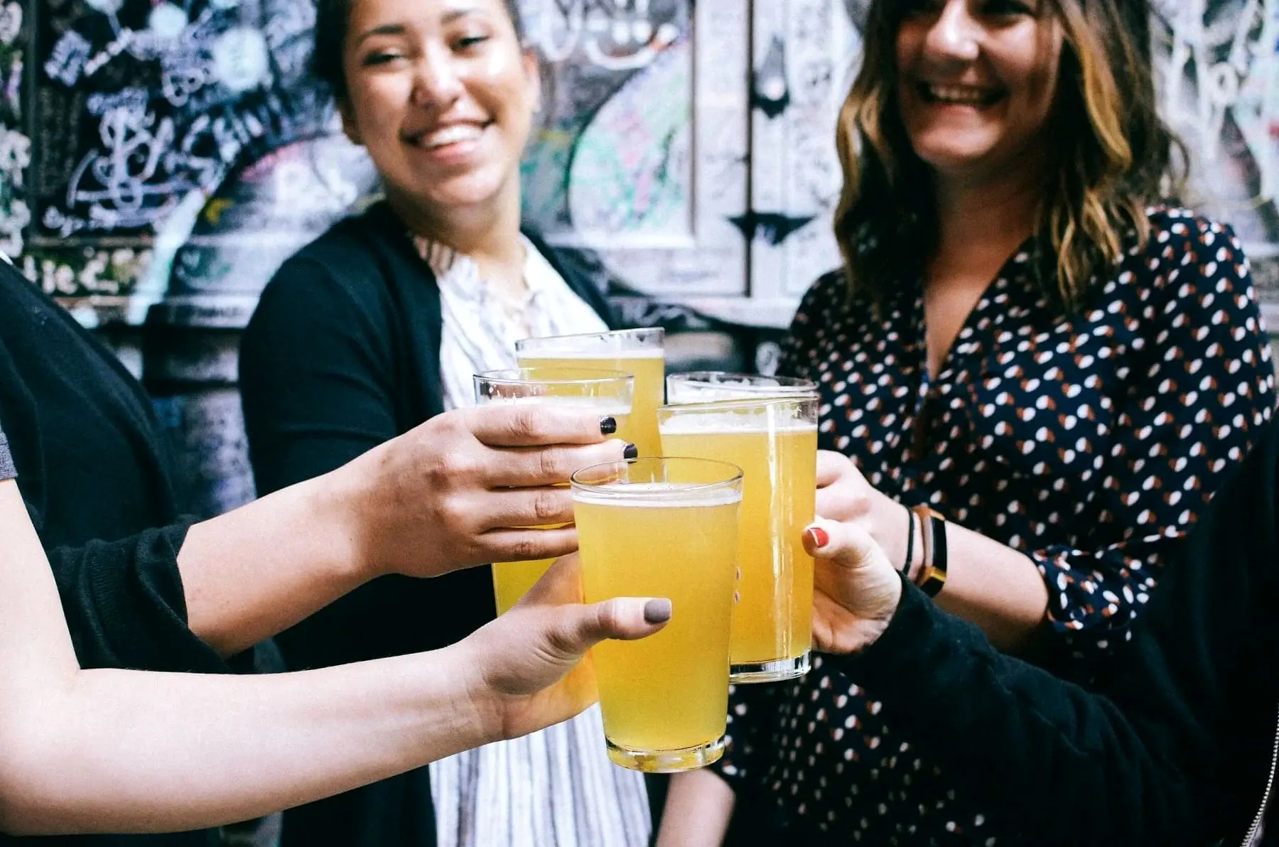 Group of people clinking glasses of beer at a gathering