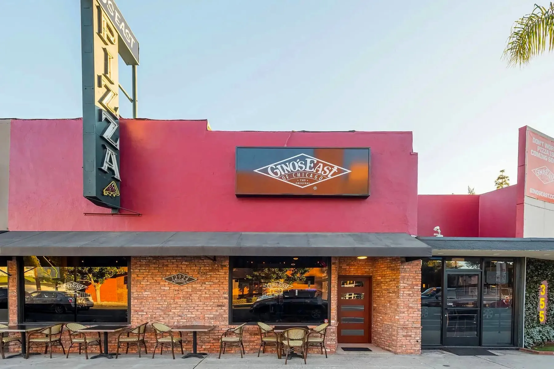 Gino&#x27;s East storefront with red facade and brick exterior in daylight