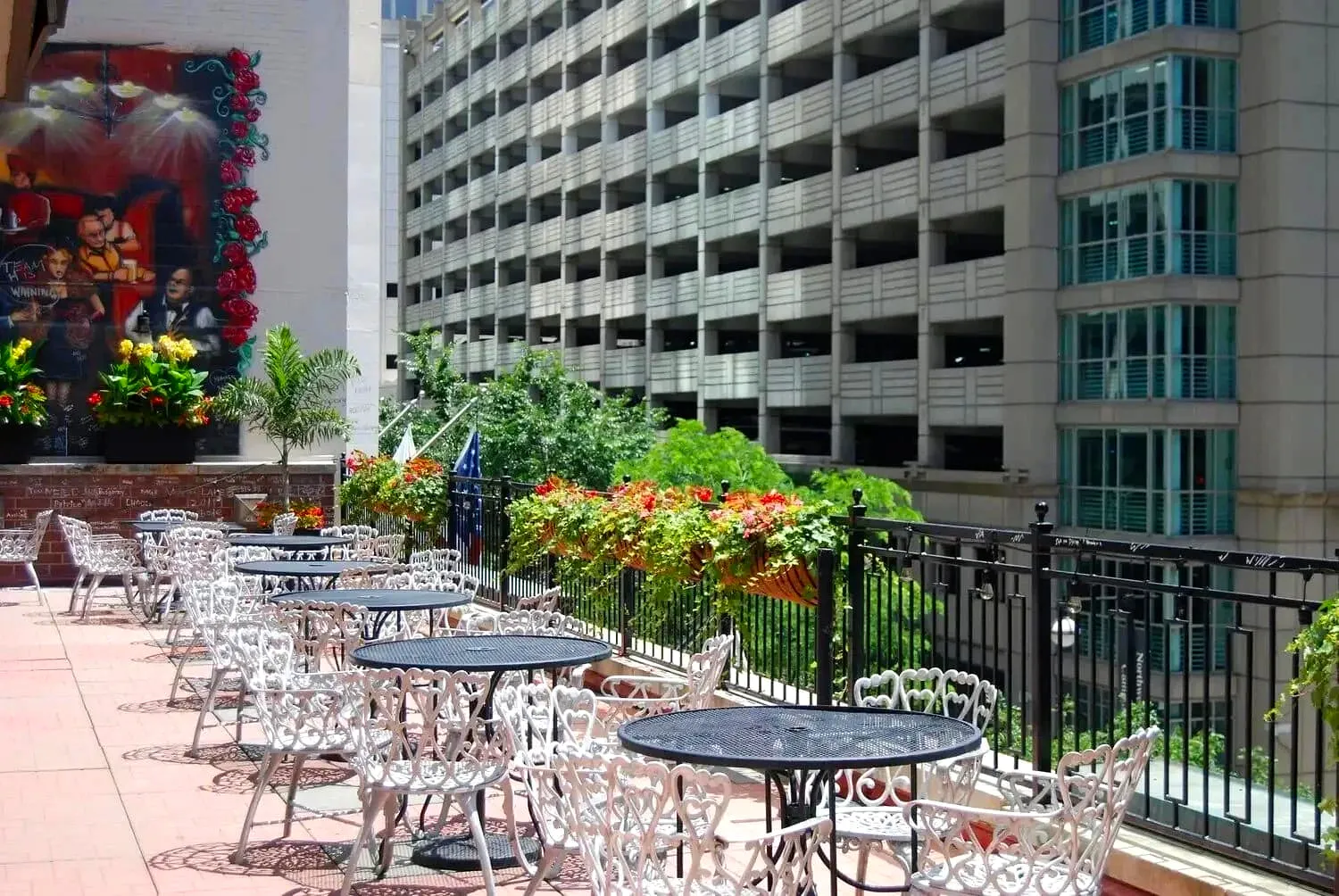 Outdoor patio seating area with white chairs and city buildings