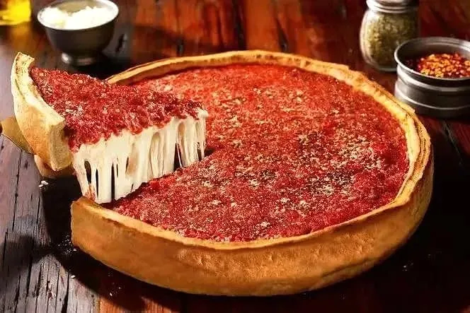 A cheese-pull shot of a pepperoni deep dish pizza dusted with parmesan
