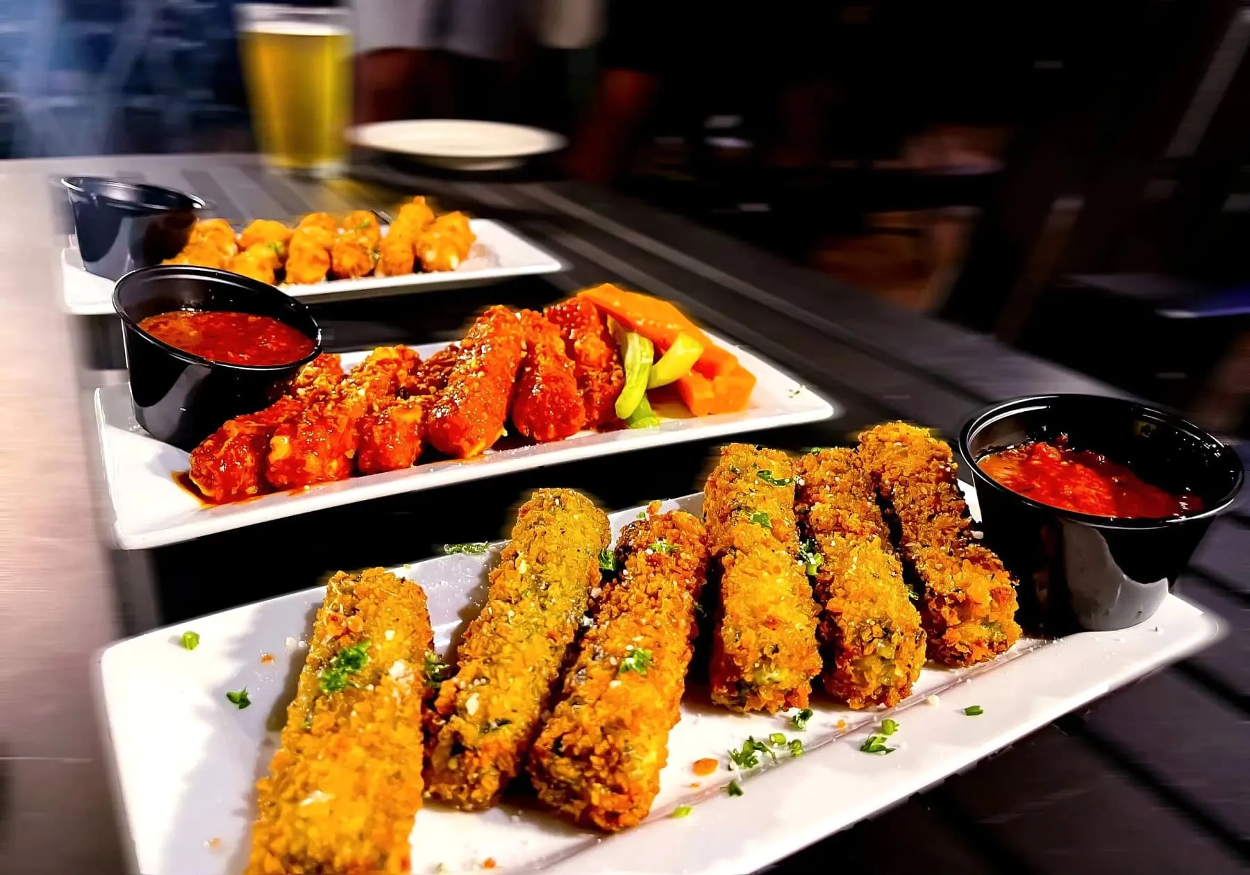 Golden fried mozzarella sticks piled on a plate with a side of marinara sauce