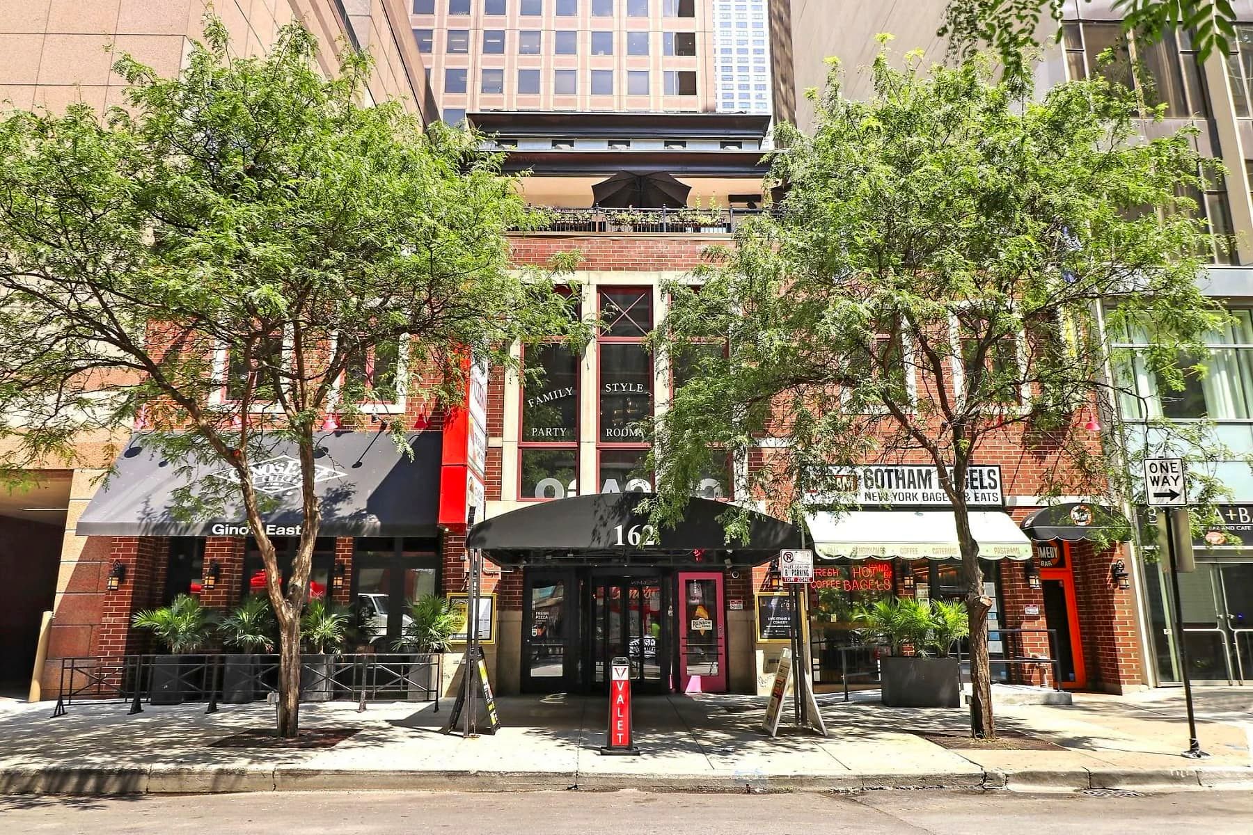 Street-level view of the Gino's East Magnificent Mile building with 'Family Style Party Rooms' painted on the third-floor windows