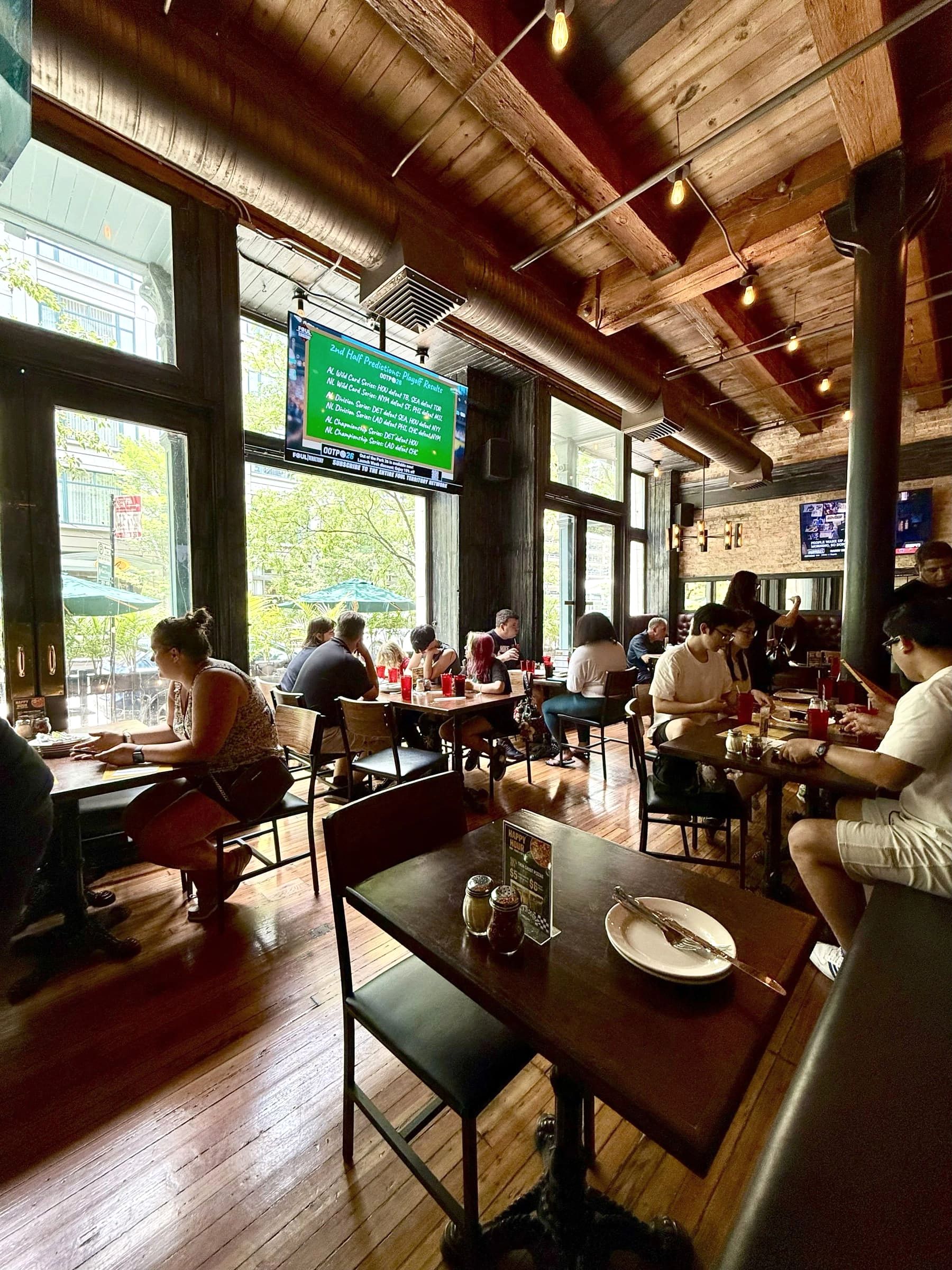 Guests dining at Gino's East South Loop while watching sports on the overhead TV