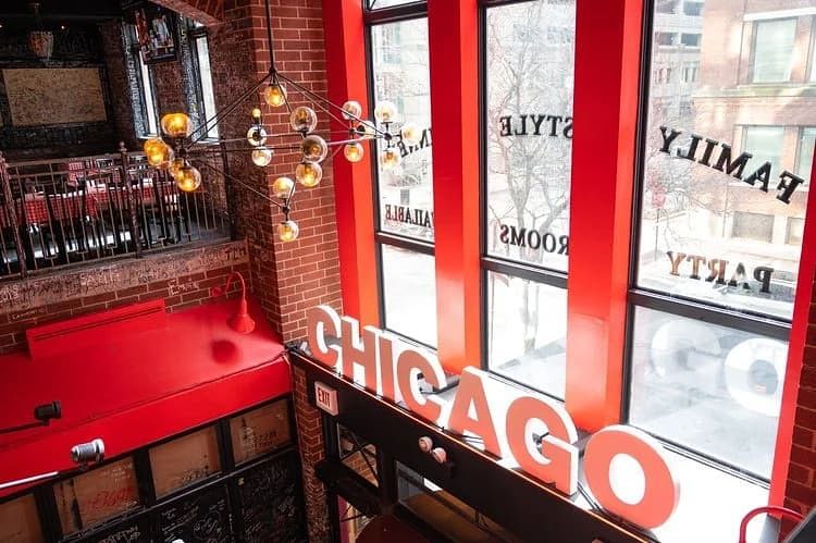 View over the red Chicago sign and second-floor balcony inside Gino's East Magnificent Mile