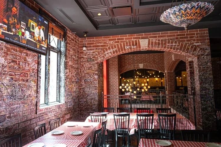 Signature-covered brick archways framing dining tables at Gino's East Magnificent Mile