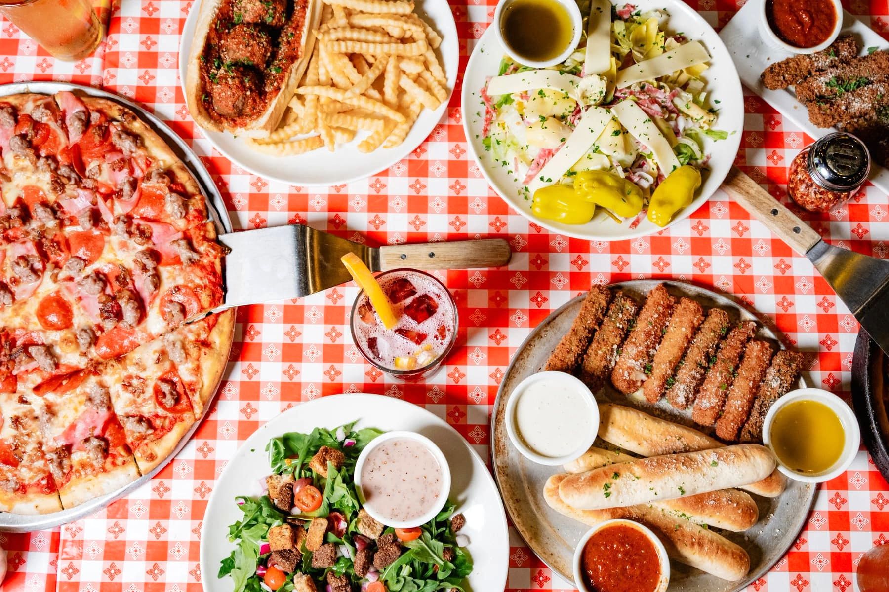 A Gino’s East catering spread of pizzas and sides