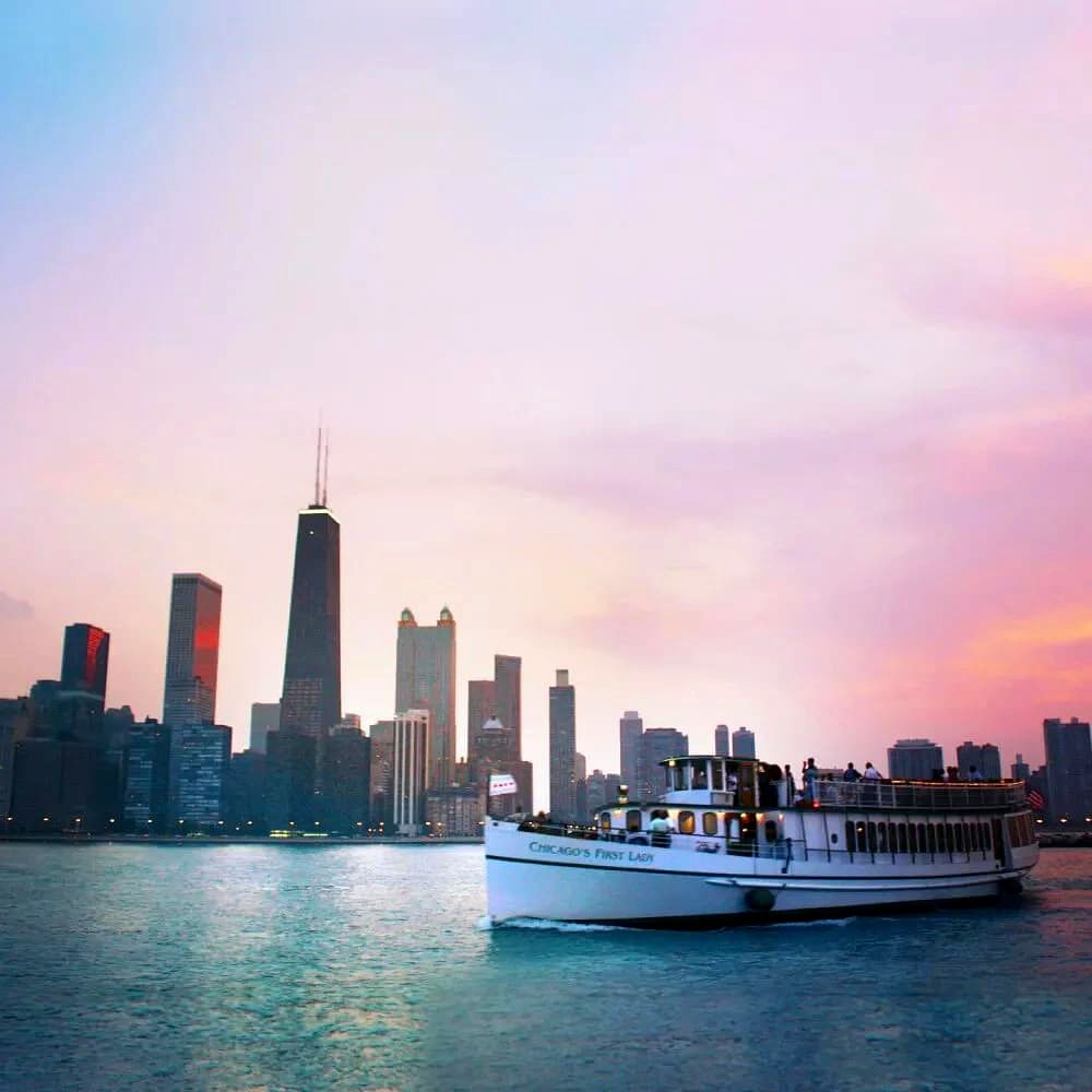 The Chicago's First Lady cruise boat on the water with the city skyline at dusk