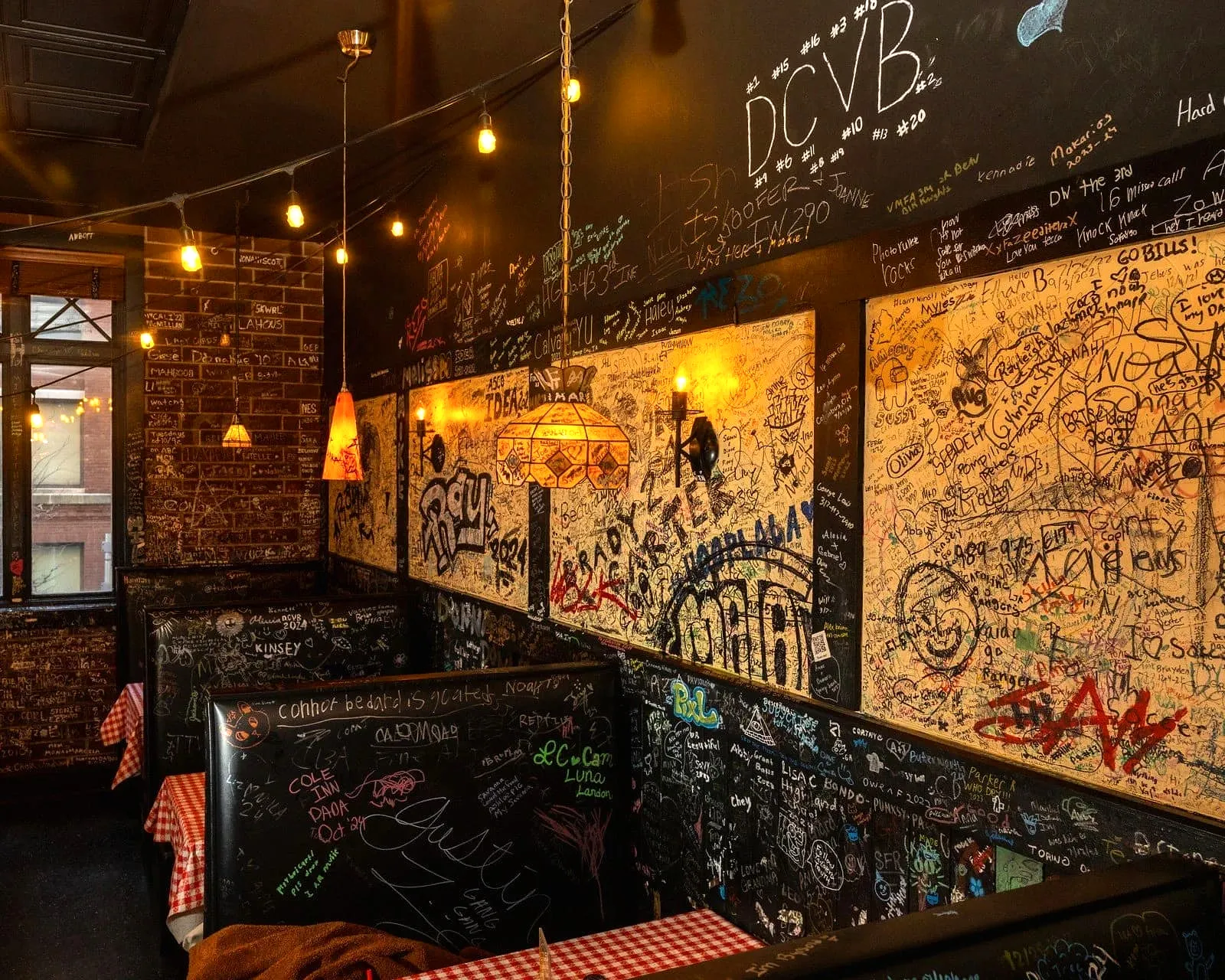 Booths and walls at Gino’s East completely covered in decades of customer signatures and doodles