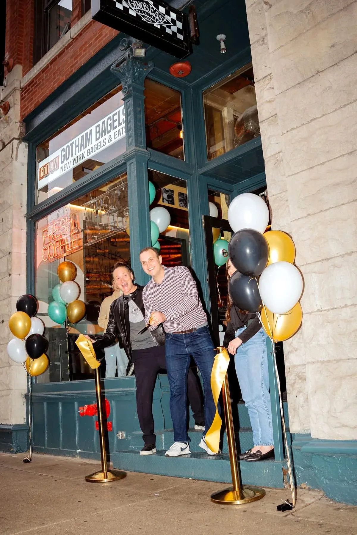 Ribbon-cutting celebration outside Gino’s East South Loop with balloons and smiling guests